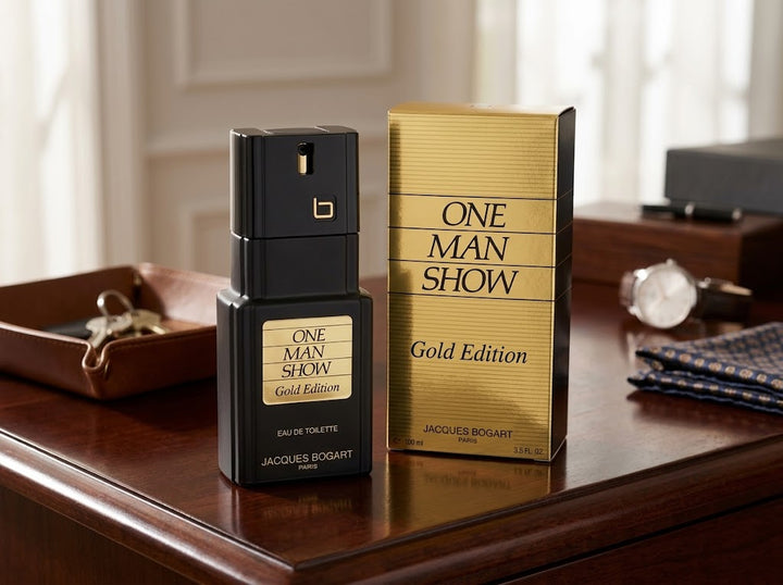 Jacques Bogart One Man Show Gold Edition Eau De Toilette 100ml bottle and gold box on a dark mahogany dresser [cite: image_15.png, image_16.png].
